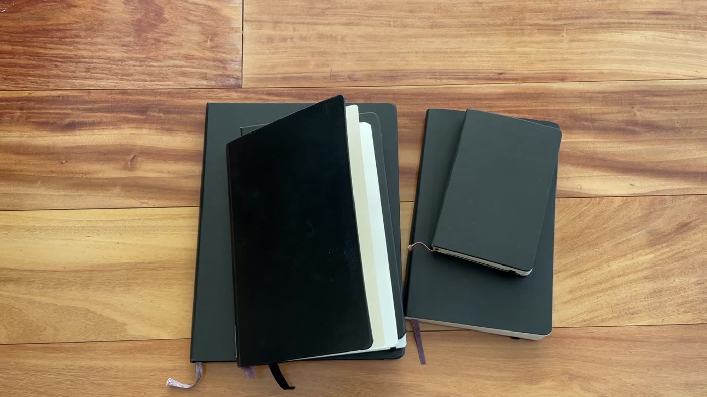 Several planner sizes laid out on a wooden floor
