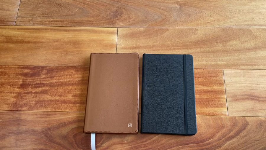 Tan and black Leatherpress notebooks shown side by side