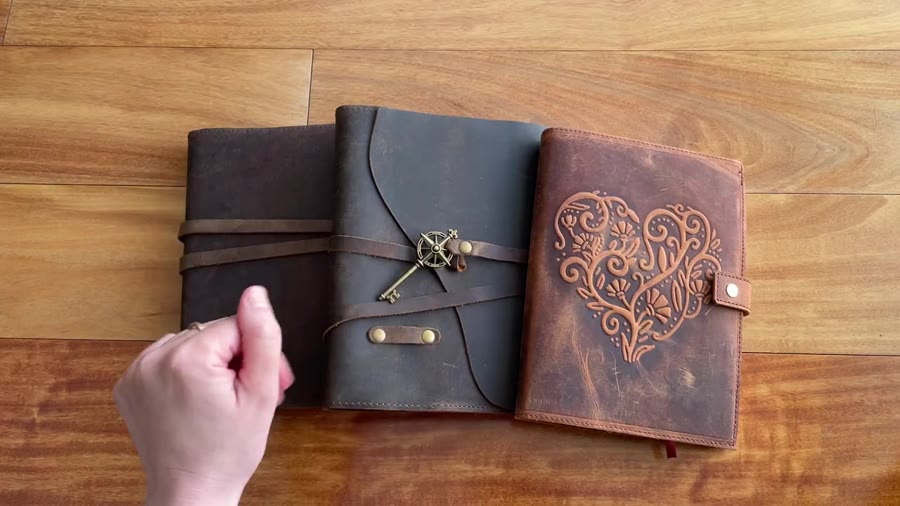 Three Nomad Crafts refillable leather journals on the table