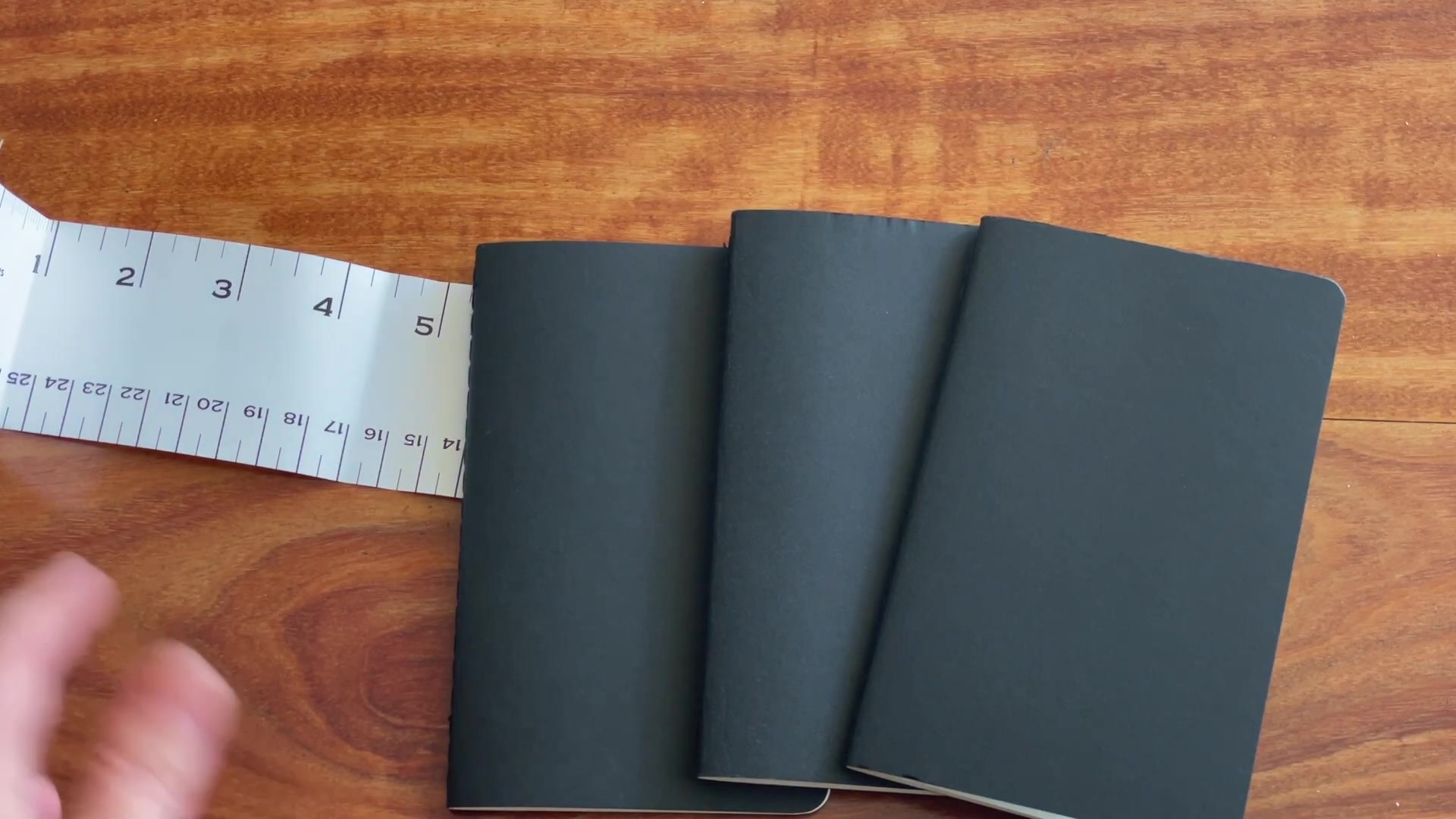 Three black Moleskine Cahier pocket notebooks laid out
