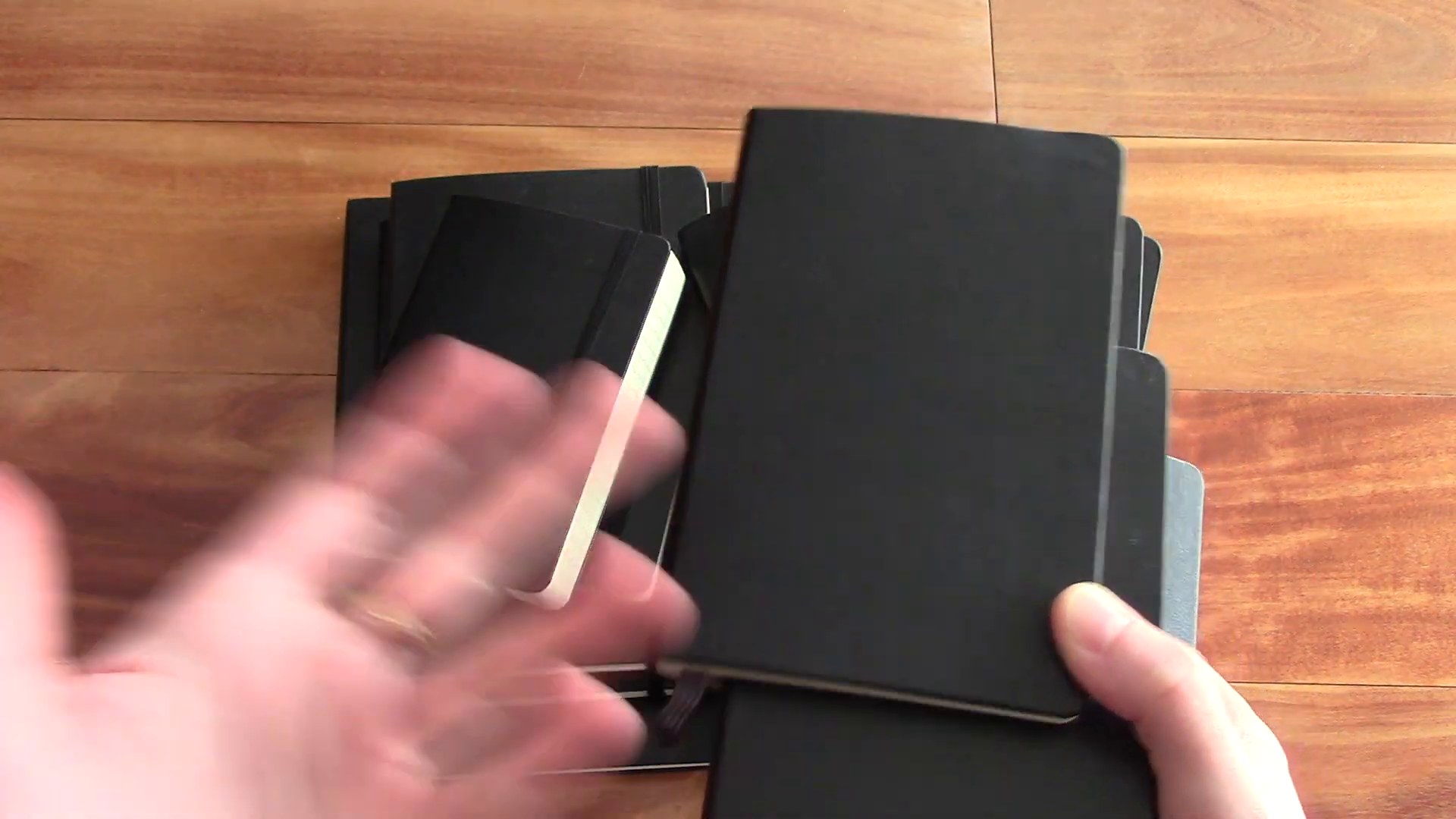 Classic black Moleskine notebook held over the collection