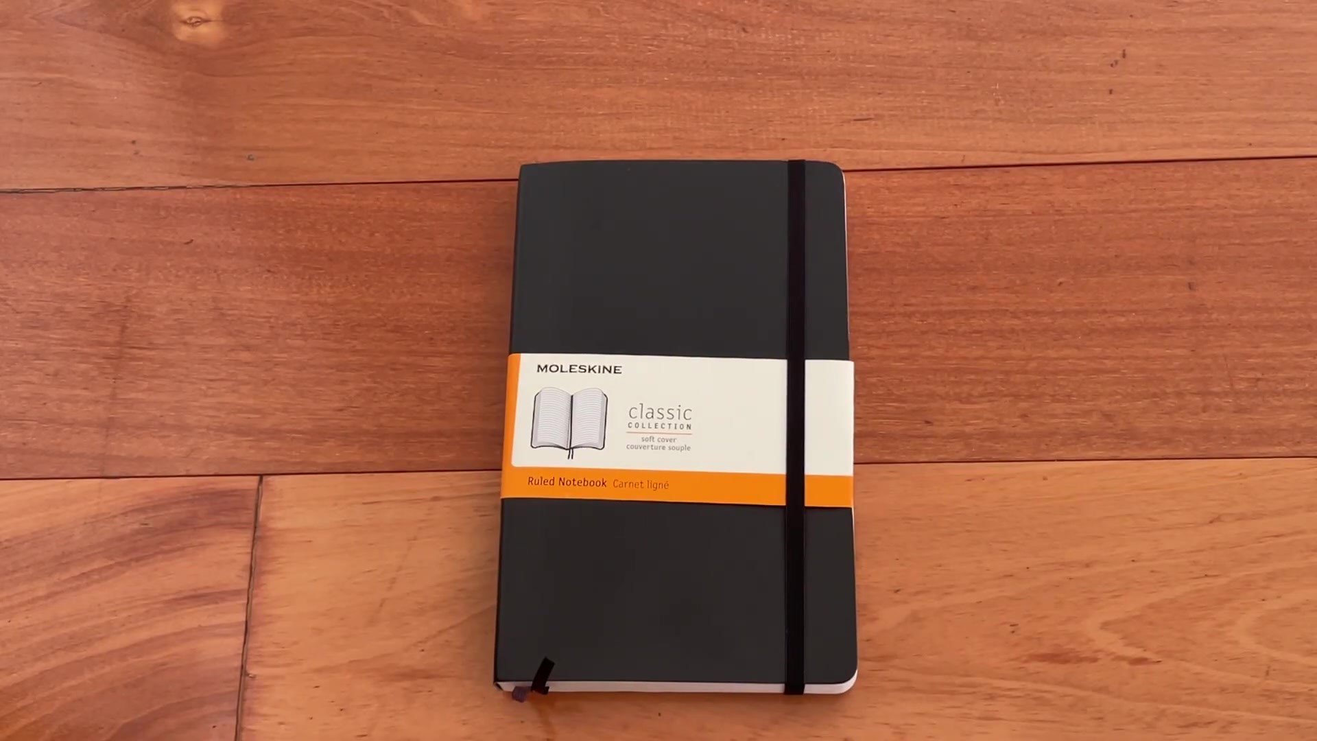 Moleskine Expanded Soft Cover Notebook Review 1 Moleskine Expanded Soft Cover Notebook with product sleeve on wooden desk