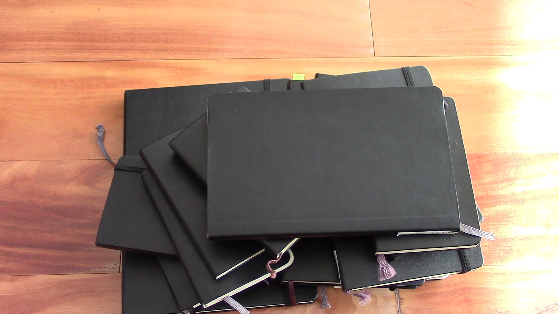 Different Moleskine notebooks stacked together showing years of use