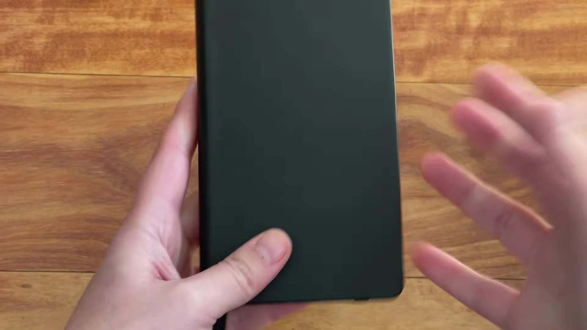 Slim black Writersblok pocket notebook shown upright in one hand
